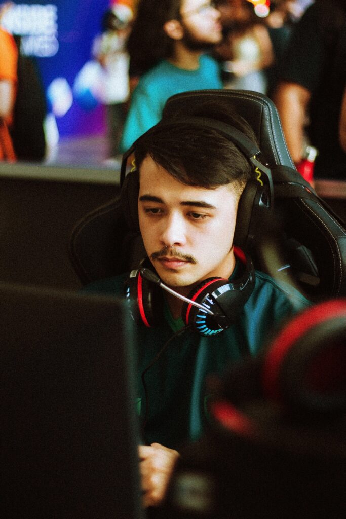 Young male gamer intensely focused at an esports tournament, wearing headphones.