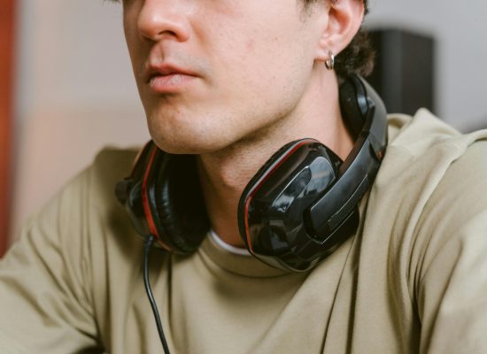 Close-up of a young man wearing a gaming headset while relaxed indoors.