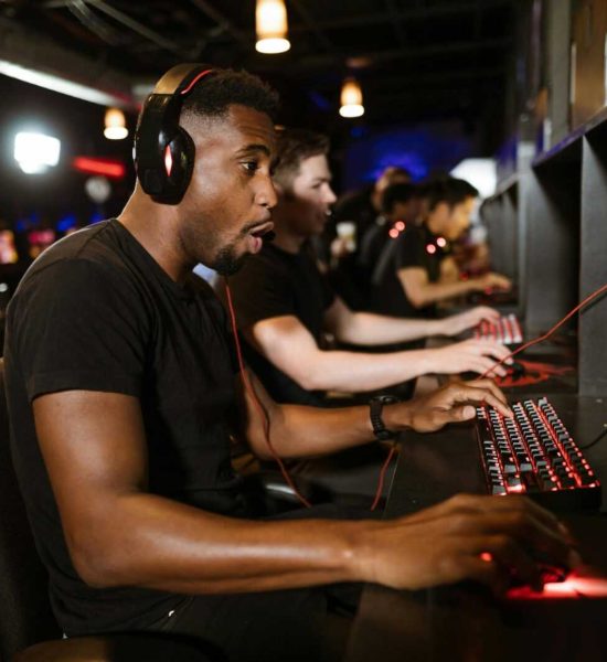Group of gamers engaging in eSports on gaming computers in an arcade.