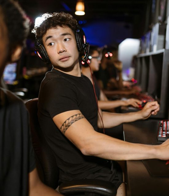 Young gamers engaged in a multiplayer session at an eSports arena with high-end gaming setups.
