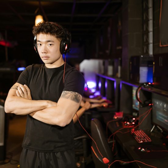 A confident gamer stands in a modern eSports arena, showcasing the gaming environment.