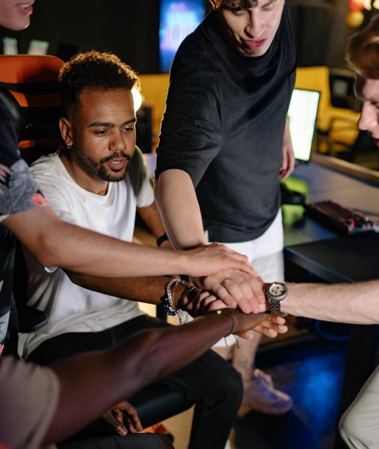 A diverse group of young adults coming together in a team building activity, symbolizing unity and teamwork.